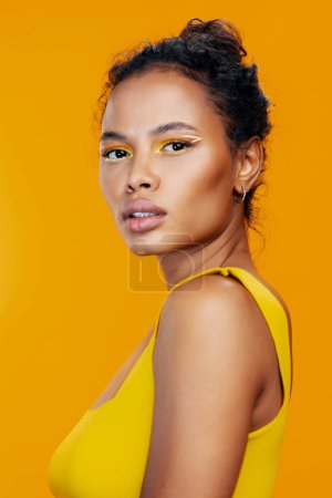 Téléchargez les photos : Femme noir style peau colorée mode cosmétologie beau sourire portrait beauté maquillage studio cosmétique modèle visage créatif jaune africain - en image libre de droit