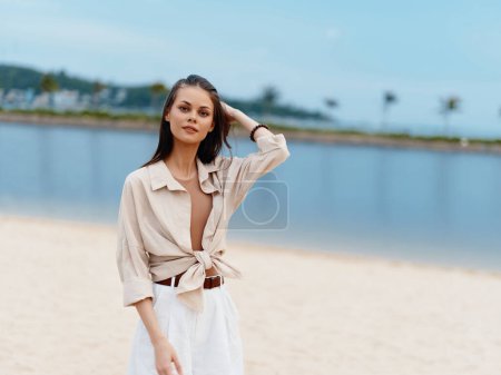 Foto de Belleza en la Naturaleza: Elegante dama caucásica disfrutando de unas vacaciones soleadas en la playa, caminando por la arena blanca, sintiéndose feliz y relajada por el océano azul - Imagen libre de derechos