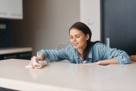 Téléchargez les photos : Femme d'affaires blanche élégante assise à la maison, travaillant sur un ordinateur portable à une table moderne dans une chambre intérieure attrayante - en image libre de droit