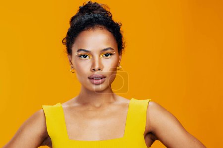 Téléchargez les photos : Femme style studio de mode jaune cosmétologie belle africaine rose peau modèle visage noir copie colorée maquillage espace cosmétique oeil beauté portrait sourire créatif ethnique - en image libre de droit