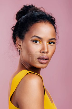 Photo for Woman beauty fashion model eye style copy african colourful cosmetic make-up studio pink yellow smile portrait beautiful space creative face cosmetology black skin ethnic - Royalty Free Image