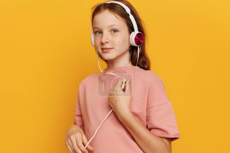 Photo for Adorable Schoolgirl in Yellow Enjoying Music with Headphones, Bringing Joy and Positive Emotion - Royalty Free Image