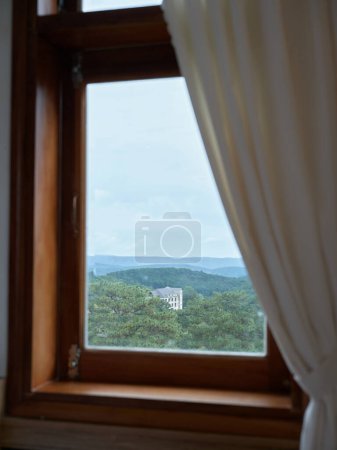 Téléchargez les photos : Vieille fenêtre avec cadre en bois et rideau lumineux dans le style traditionnel de la maison avec une belle vue. Photo de haute qualité - en image libre de droit