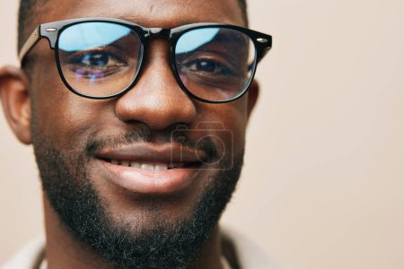 Téléchargez les photos : Homme beige moderne lunettes de soleil coiffure style tenue africaine portrait veste d'intérieur afro américain modèle noir lunettes mâle afro look élégant mode jeune - en image libre de droit
