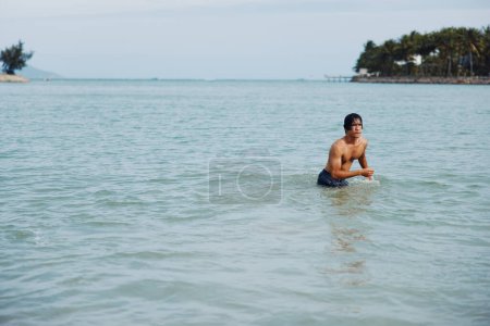 Photo for Happy Asian Man Swimming in the Tropical Ocean, Enjoying Vacation on the Beach - Royalty Free Image