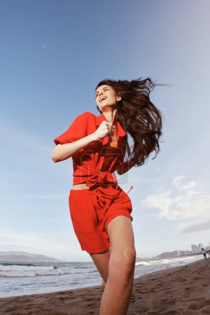 Téléchargez les photos : Femme de mode à la mode : Le joyeux coucher de soleil courir le long de la belle plage - en image libre de droit