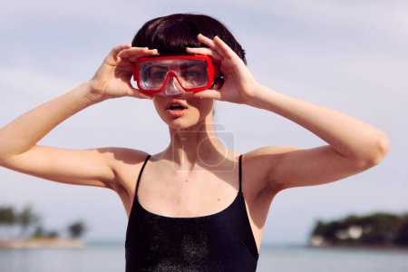 Téléchargez les photos : Femme joyeuse plongée avec tuba en maillot de bain rouge à la mode : Un portrait joyeux sur une plage tropicale. - en image libre de droit