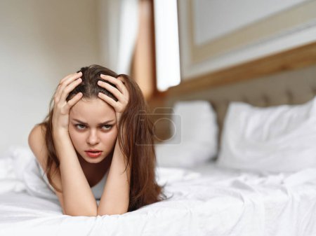 Foto de Mujer joven acostada en la cama por la mañana con resaca y dolor de cabeza, problemas de migraña por la mañana. Foto de alta calidad - Imagen libre de derechos