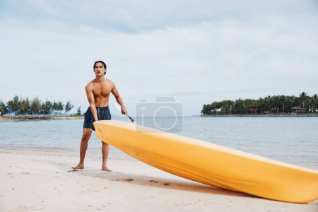 Photo for Serene Summer: Happy Asian Man Kayaking on Tropical Beachs of Paradise - Royalty Free Image