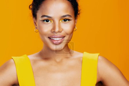 Téléchargez les photos : Femme modèle ethnique noir studio beauté jaune copie sourire créatif cosmétique peau style rose portrait cosmétologie coloré mode maquillage bel espace africain visage - en image libre de droit