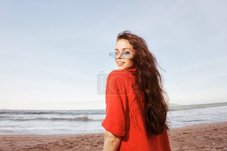 Foto de Mujer sonriente disfrutando de unas vacaciones de verano sin preocupaciones en la colorida playa - Imagen libre de derechos