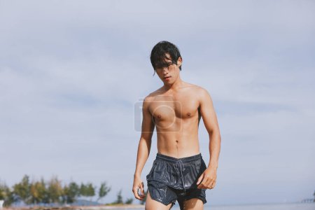 Photo for Swim, Splash, and Smiling Joy: A Young Asian Man enjoying a Tropical Vacation at the Beach - Royalty Free Image