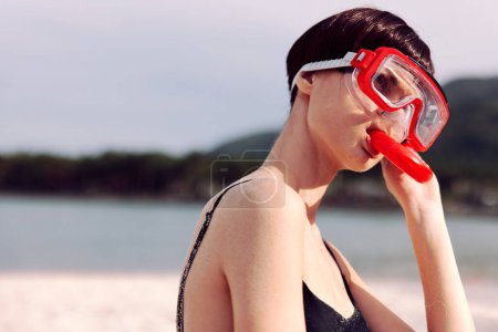 Foto de Moda roja: Mujer sonriente haciendo snorkel en un paraíso tropical - Imagen libre de derechos