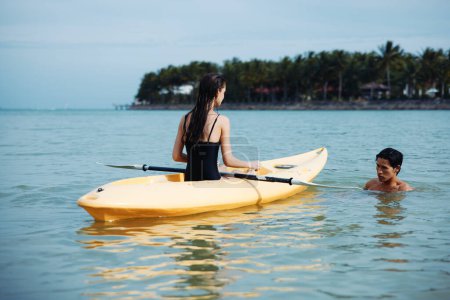 Téléchargez les photos : Kayak Adventure : Un voyage de pagaie en couple insouciant sur un magnifique lac tropical au coucher du soleil - en image libre de droit
