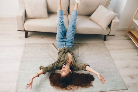 Foto de Cómodo hogar: Un acogedor y moderno apartamento con una mujer feliz acostada en el sofá, relajándose y disfrutando de unas vacaciones tranquilas - Imagen libre de derechos