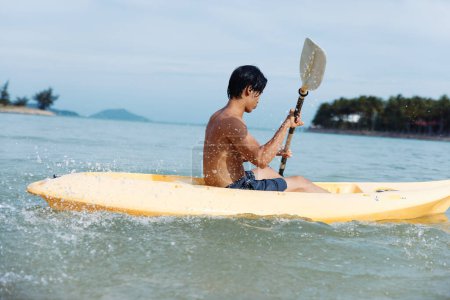 Foto de Aventura de verano: Hombre feliz Kayak en el paraíso tropical - Imagen libre de derechos