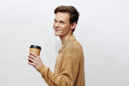 Photo for Stylish Caucasian Man Smiling While Holding a Hot Beverage to Go in a Modern Cafe - Royalty Free Image