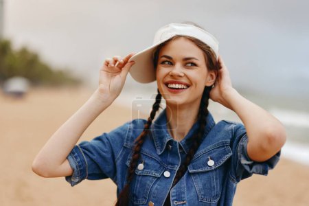 Foto de Mujer joven sonriente en sombrero de verano, disfrutando de la naturaleza en el parque - Imagen libre de derechos