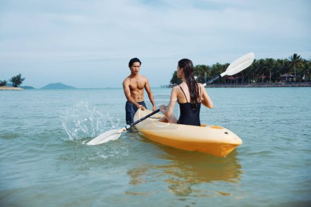 Téléchargez les photos : Kayak Bliss : Une aventure active de couples insouciants sur le magnifique océan tropical au coucher du soleil - en image libre de droit