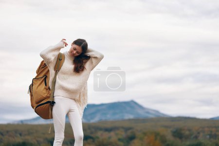 Téléchargez les photos : Femme souriante profitant de l'aventure en montagne : mode de vie touristique heureux au printemps - en image libre de droit