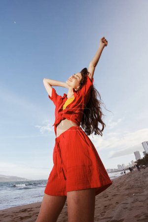 Photo for Free-Spirited Woman Dancing with Joy on a Sunny Beach - Royalty Free Image