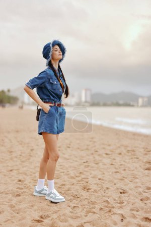 Foto de Atractiva joven mujer disfrutando de unas vacaciones de verano en la playa, con el mar azul y el cielo como fondo. - Imagen libre de derechos