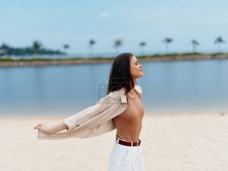 Téléchargez les photos : Beauté au Paradis : Une jeune femme profite de vacances d'été ensoleillées sur une plage tropicale avec des vagues de l'océan bleu étincelant - en image libre de droit