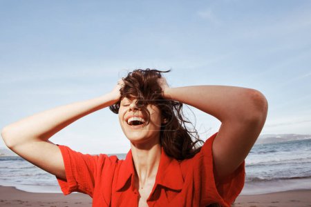 Foto de Mujer sonriente feliz disfrutando de libertad y alegría en una playa soleada - Imagen libre de derechos