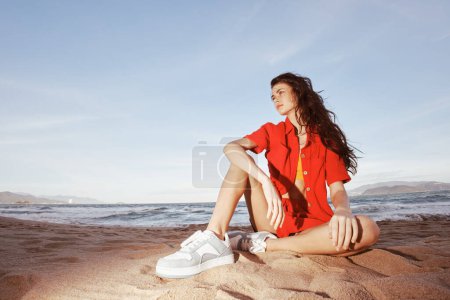 Photo for Smiling Woman in Trendy Beach Fashion, Sitting on Sand: Summer Emotion - Royalty Free Image