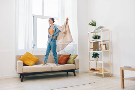 Photo for Jumping for Joy in a Playful Home: A Carefree Woman Dancing and Singing in a Beautiful Living Room - Royalty Free Image