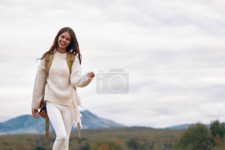 Photo for Mountain Adventure: Smiling Woman Climbing Cliff - Royalty Free Image