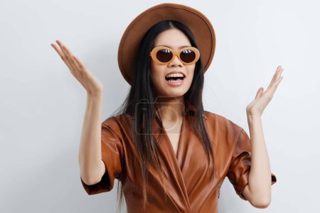 Foto de Mujer sombrero cara beige retrato gafas de sol lindo asiático modelo cosmético salón estilo de vida hermosa feminidad moda belleza viaje pelo vacaciones atractivo glamour - Imagen libre de derechos