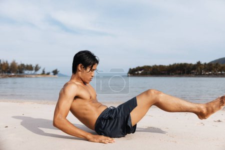 Téléchargez les photos : Athlète asiatique actif embrassant la forme physique sur la plage de sable pendant le coucher de soleil d'été" - en image libre de droit