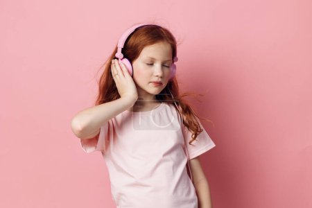 Téléchargez les photos : Personne musique petits enfants enfance enfant mignon écouteurs fond portrait jeune fille profiter de la technologie audio féminine écouteurs écouter casque audio - en image libre de droit