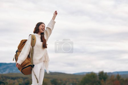 Téléchargez les photos : Aventure en montagne : Femme souriante sur la falaise, profiter du sac à dos au printemps - en image libre de droit