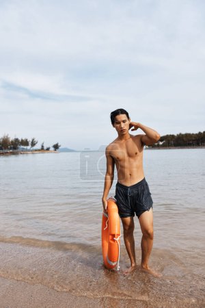 Téléchargez les photos : Sauveteur sur une plage : vigilance et joie pour assurer la sécurité dans l'océan bleu. - en image libre de droit
