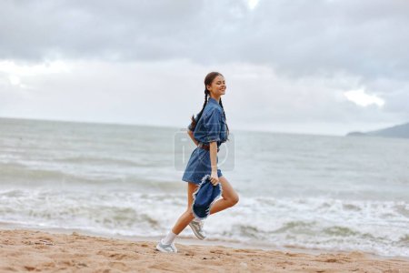 Photo for Active Beach Runner Enjoying the Summer Sunset: A Young Woman Training and Exercising on the Sand, Feeling the Freedom and Beauty of the Ocean and Sky. - Royalty Free Image