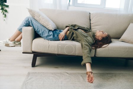 Foto de Mujer triste y preocupada sentada en el sofá, expresando depresión y ansiedad en casa - Imagen libre de derechos