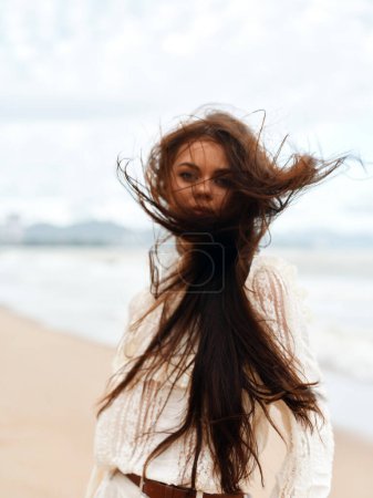 Foto de Belleza rubia: Joven y atractiva mujer con el pelo largo, disfrutando de las vacaciones de verano en una playa ventosa - Imagen libre de derechos