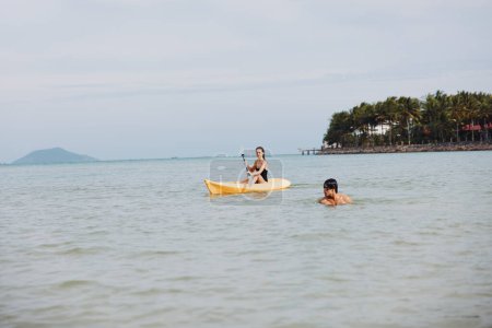 Téléchargez les photos : Couple aventureux Faire du kayak sur un lac tropical, embrasser la sérénité de la nature - en image libre de droit