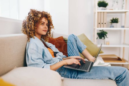 Téléchargez les photos : Femme souriante utilisant un ordinateur portable dans un bureau à domicile confortable, embrassant le mode de vie freelance moderne - en image libre de droit