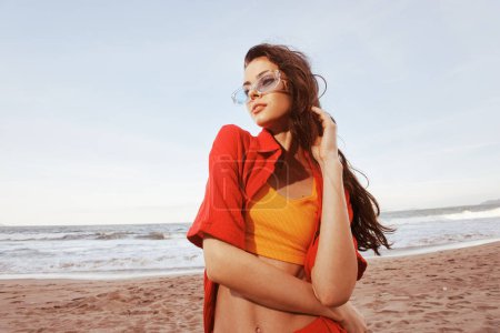 Téléchargez les photos : Femme souriante à la plage, Faire place à la liberté avec des lunettes de soleil colorées - en image libre de droit