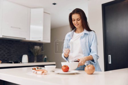 Foto de Atractiva mujer cocinando comida saludable en la cocina moderna, concepto de estilo de vida para la fotografía publicitaria - Imagen libre de derechos
