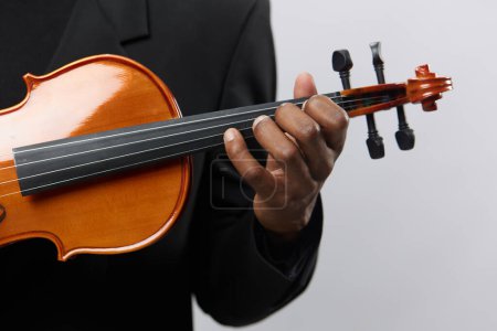 Téléchargez les photos : Gros plan d'un homme en costume noir jouant du violon sur fond blanc, concept de performance musicale - en image libre de droit
