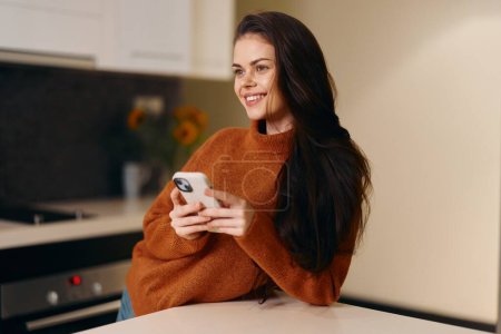 Photo for Connected Beauty: A Young Woman Using Smartphone at Home - Portrait of Attractive Female Holding Cellphone on Sofa - Royalty Free Image