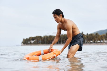 Téléchargez les photos : Alerte Asiatique Sauveteur Assurer la sécurité sur Sunny Beach - en image libre de droit