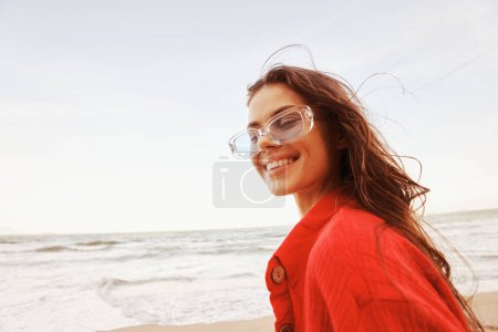 Téléchargez les photos : Femme insouciante profitant du coucher de soleil sur la plage colorée - en image libre de droit
