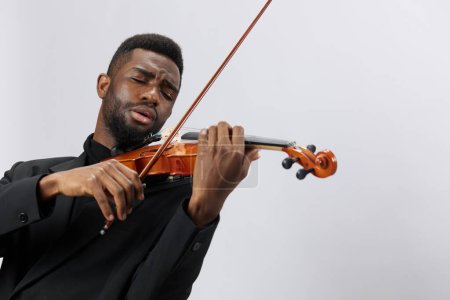 Téléchargez les photos : Homme en costume jouant du violon sur fond blanc, musicien afro-américain jouant de la musique classique avec instrument - en image libre de droit