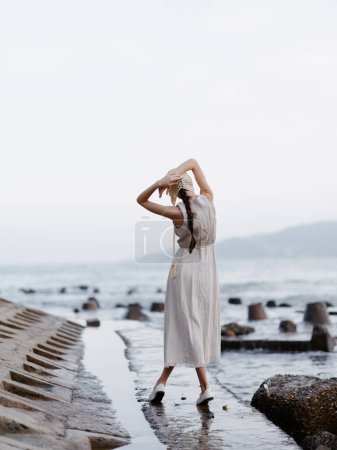 Téléchargez les photos : Beauté estivale : Une jeune femme profite d'une journée relaxante sur une plage de sable blanc, admirant la vue imprenable sur l'océan bleu - en image libre de droit