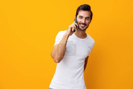 Photo for Phone man technology cyberspace message portrait yellow smiling communication business lifestyle happy studio pointing surprise mobile eyeglass space copy smartphone toothy phone smile - Royalty Free Image
